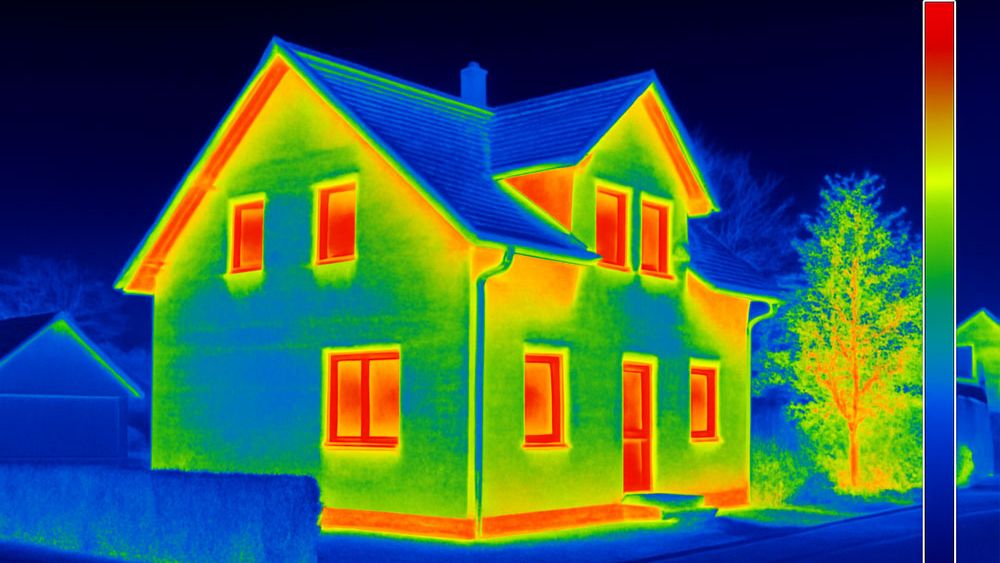 Thermal image of a house used for window leak detection, showing heat loss around windows and doors in red and orange, with cooler walls in blue, highlighting insulation issues.