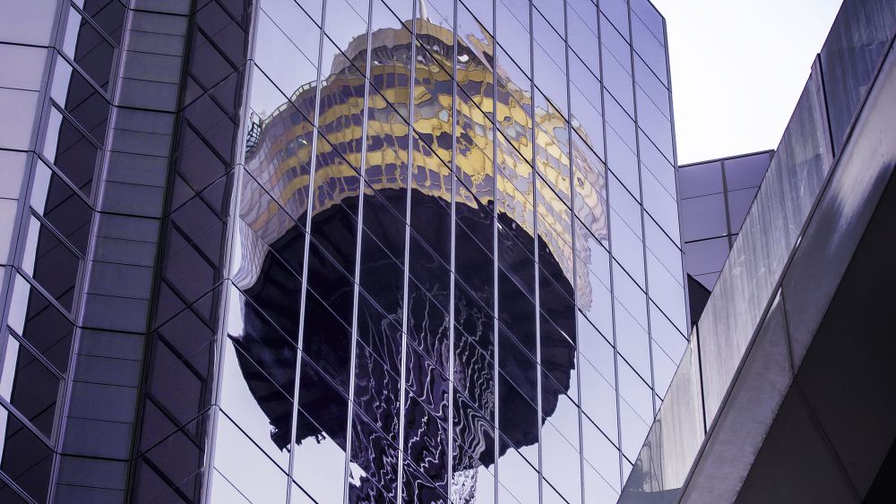 Reflection of Sydney Tower in the glass facade of a modern commercial building.